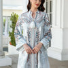 Une femme modélise une élégante longue abaya perlée de diamants avec broderie florale dans des tons blancs et bleus.