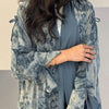 Eine Frau trägt einen fließenden Tie-Dye Abaya Kaftan in blauen und grauen Tönen.