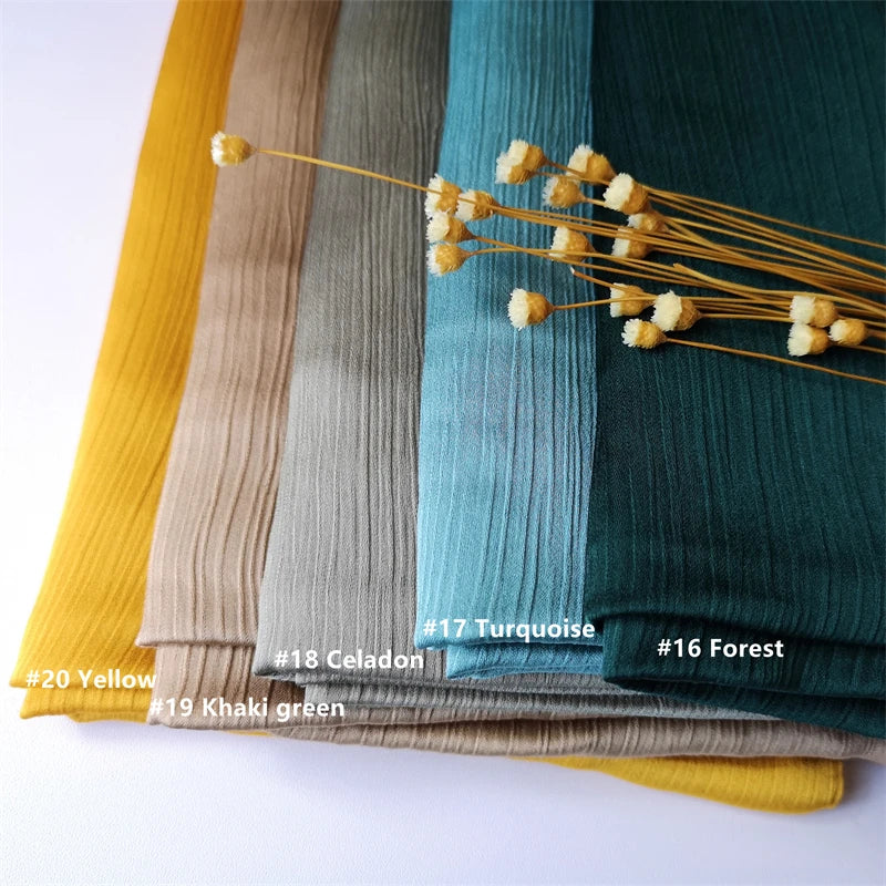 Eine Sammlung von Crinkle-Satin-Chiffon-Hijabstoff in verschiedenen Schattierungen, darunter Gelb, Khaki-Grün, Celadon, Türki
