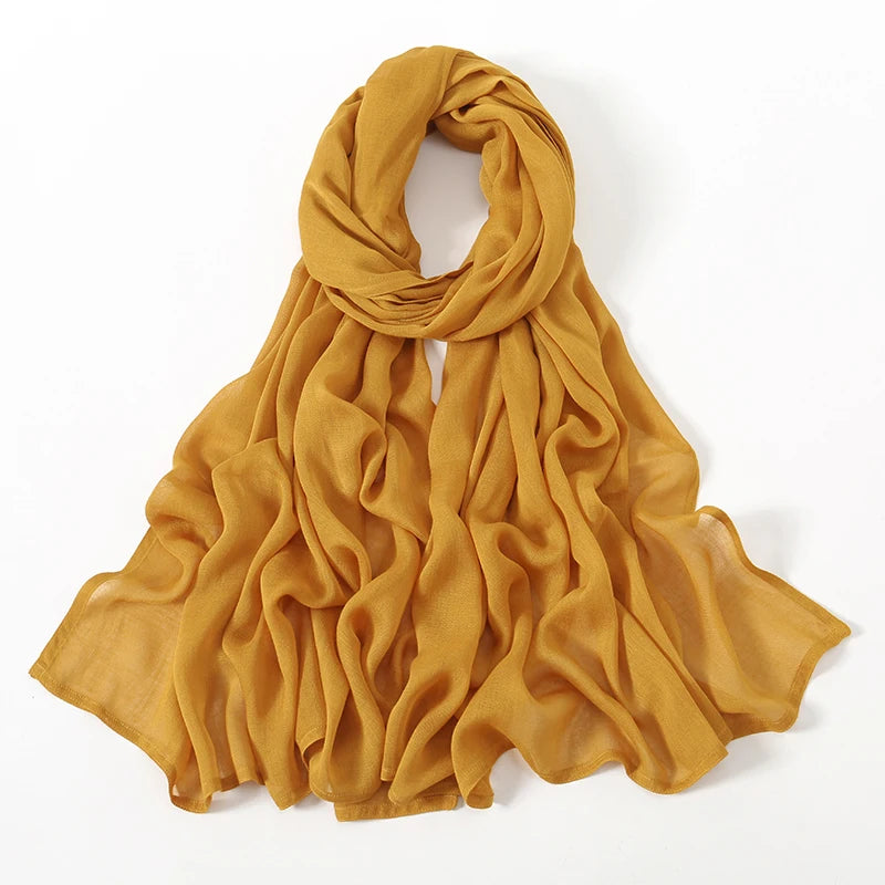Fließender senfgelber Viscose-Hijab, elegant um den Hals und die Schultern drapiert.