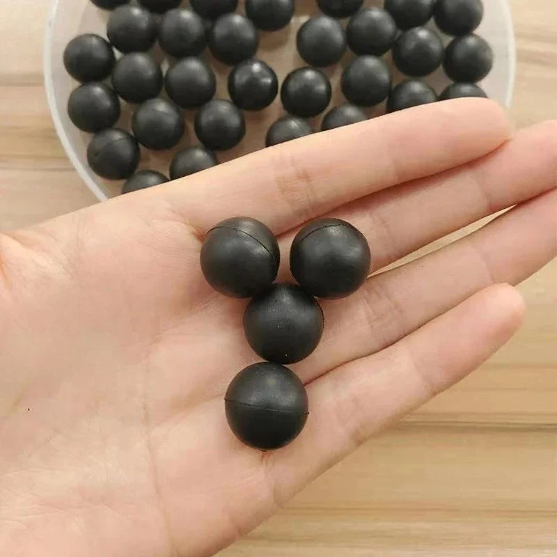 Eine Hand hält mehrere schwarze, industrielle Gummidichtungsbälle in einem weißen Behälter.