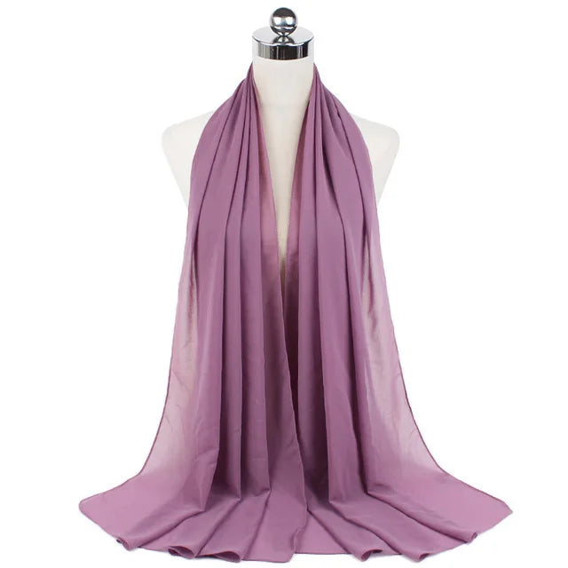 A mauve chiffon hijab scarf draped around a mannequin neck.