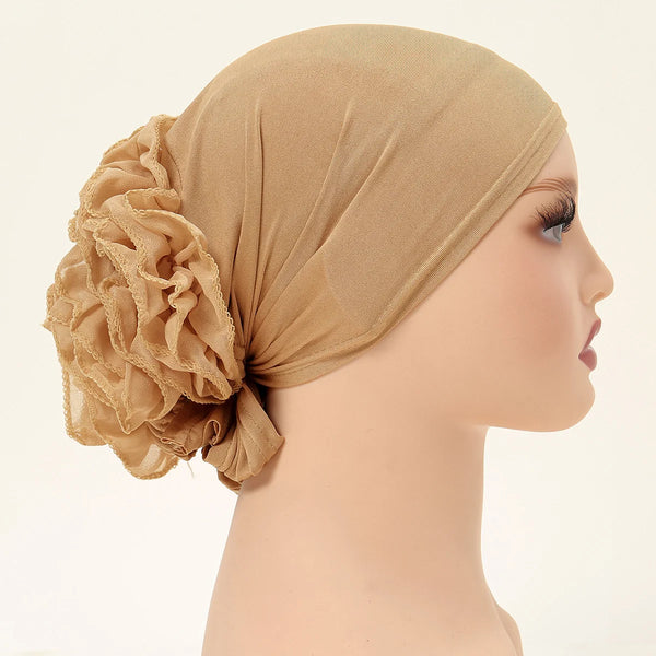 A beige lace flower volumizer hijab cap worn on a mannequin's head.
