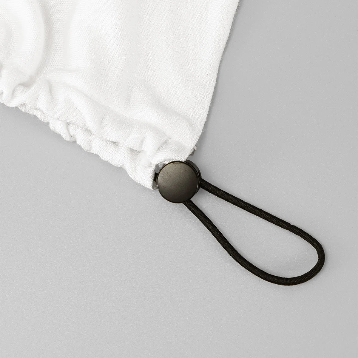 Nahaufnahme einer weißen Baumwoll-Hijab-Kappe mit schwarzem Schnurdetails.
