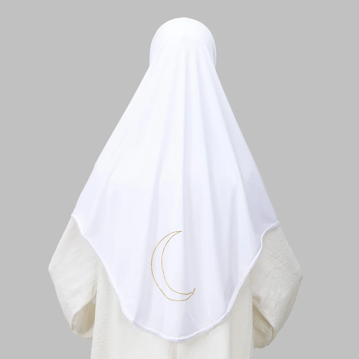 Un foulard hijab blanc avec une broderie de croissant de lune doré sur un vêtement de couleur claire.