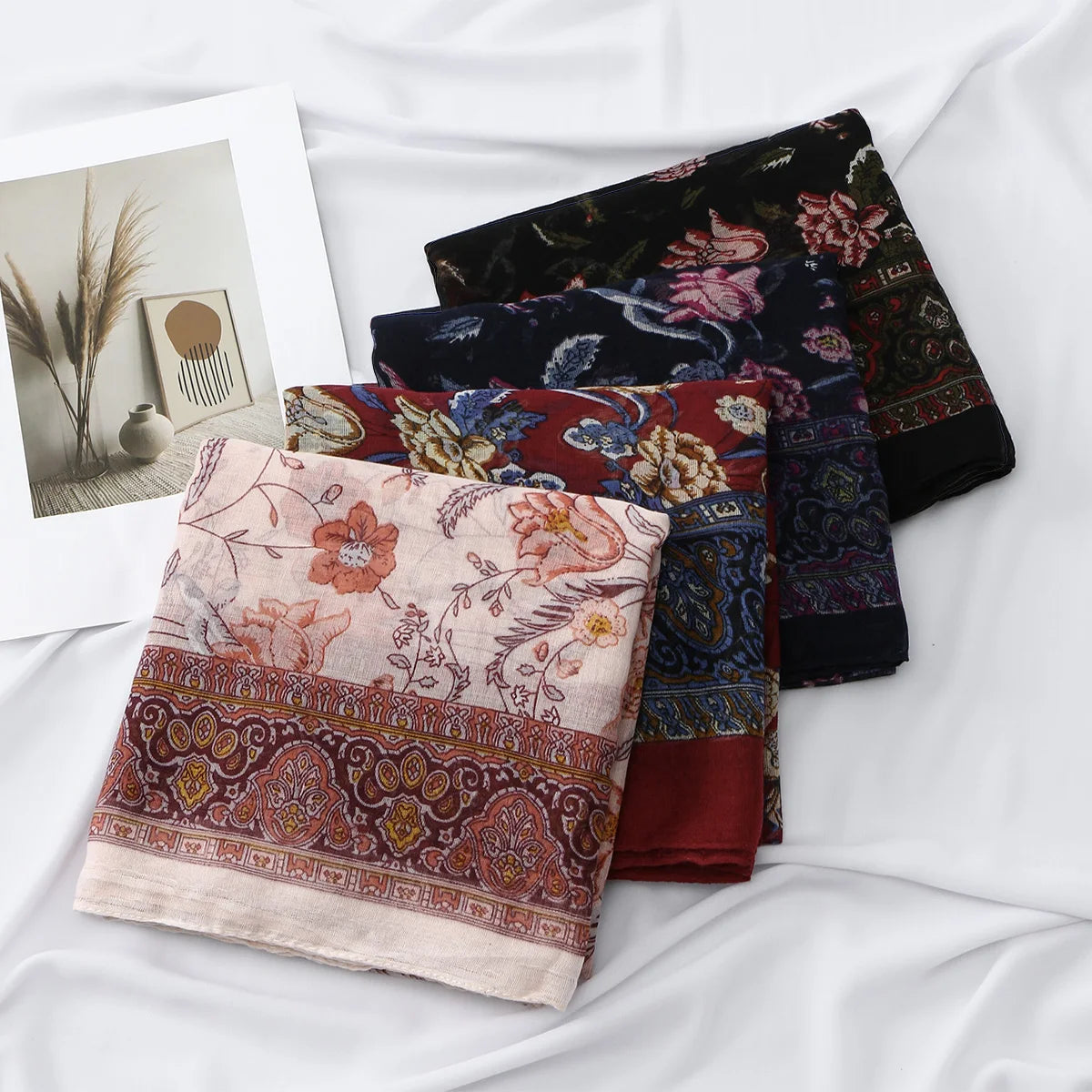 Pila de pañuelos de hijab de algodón viscosa estampados florales y paisley en tonos granate, azul oscuro y negro