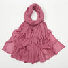 Étole en rayon poussiéreux rose poudré, froncée et drapée autour du cou et des épaules.