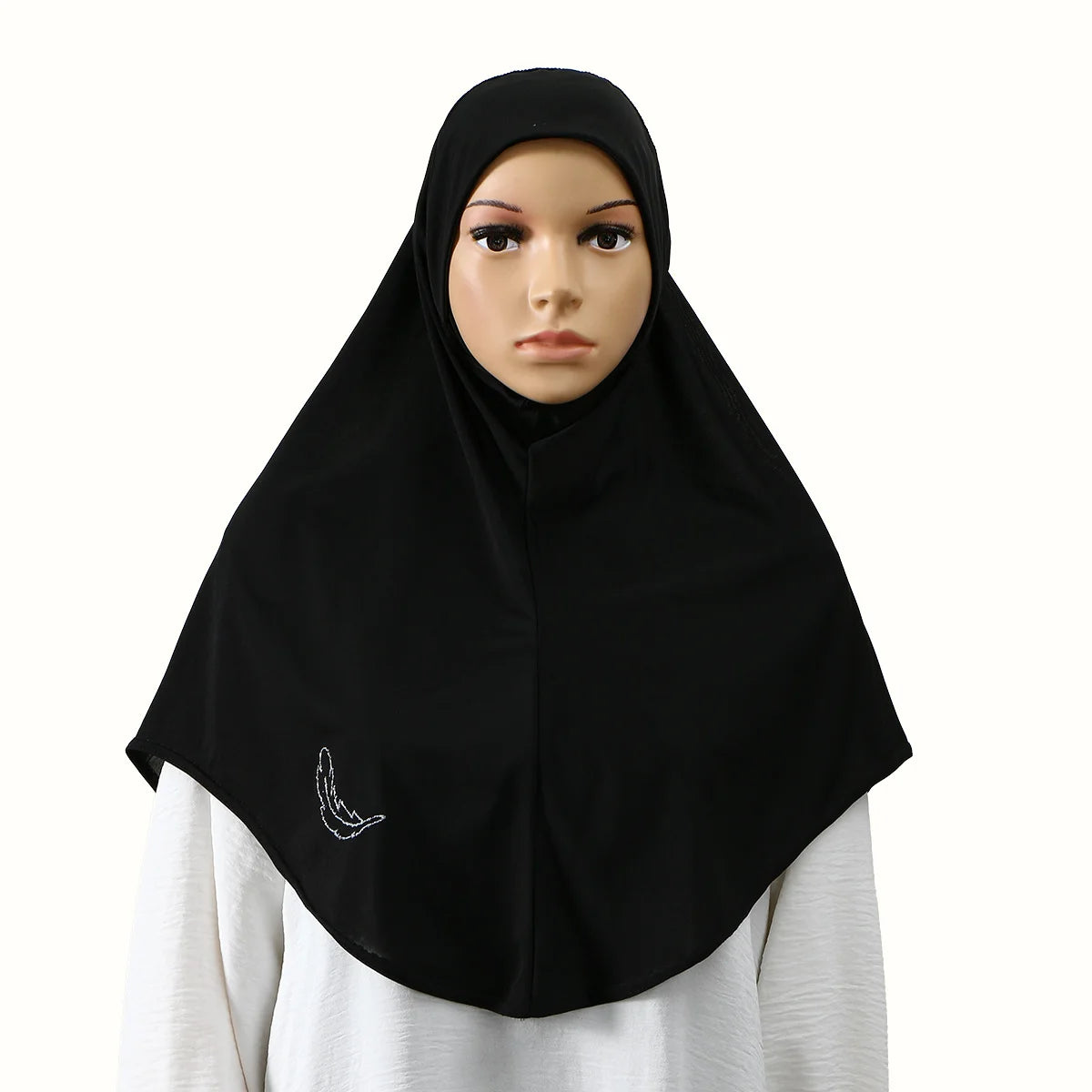 Une femme portant un hijab noir avec une subtile broderie blanche.