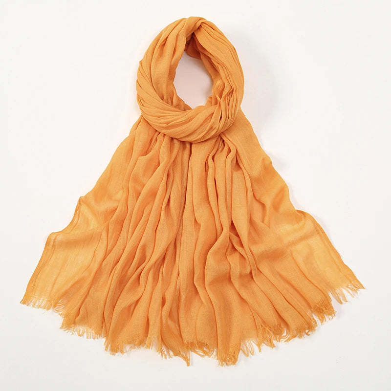 Pañuelo modal de bambú color mostaza anaranjado fluido con detalles de flecos.