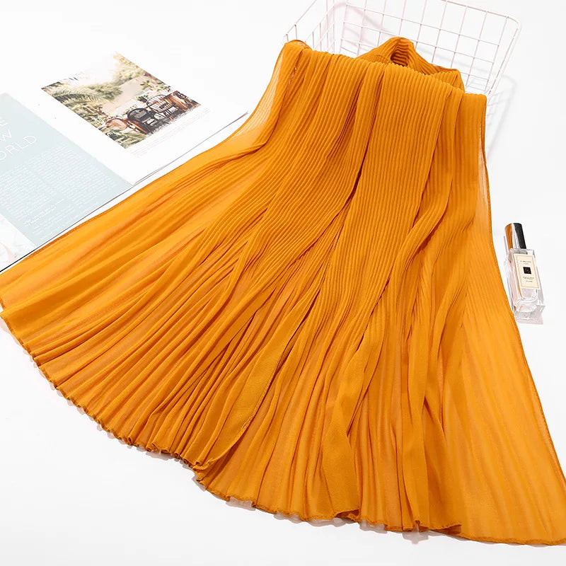 Fließender orangefarbener Crinkle-Chiffon-Hijab-Schal auf weißem Hintergrund.
