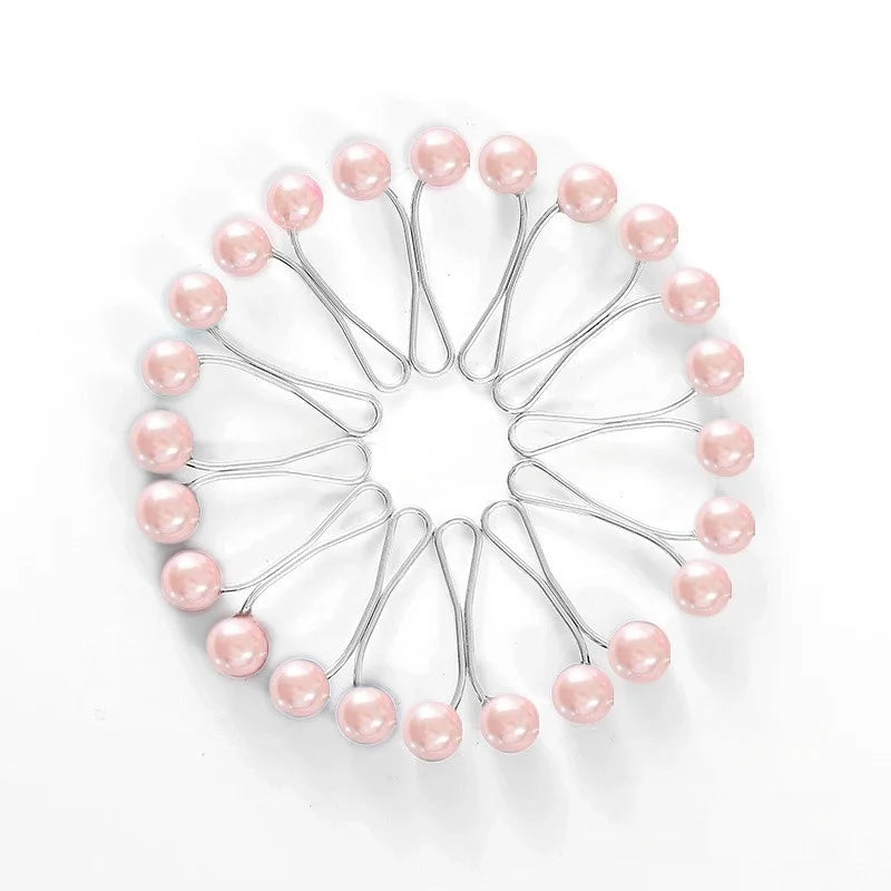 Disposition circulaire de douze épingles et pinces décoratives en argent sur fond blanc.