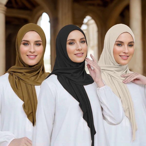 Three women wearing soft modal jersey instant hijab scarves in olive green, black, and beige tones.