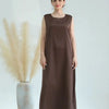 A woman models a long, flowing brown modest abaya dress against a light background.