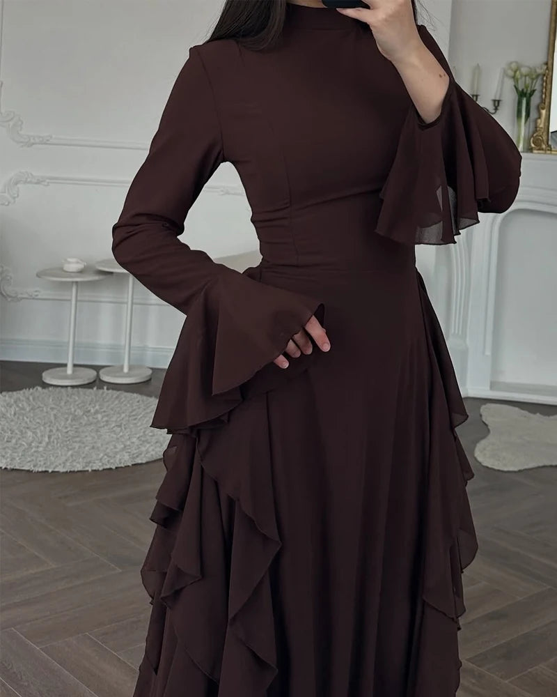 A dark brown elegant high-waisted long-sleeve A-line maxi dress shown on a model.