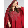 Una mujer vistiendo un abaya maxi rojo fluido con mangas de murciélago y un pañuelo a juego.