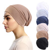 Une femme modélise un bonnet/foulard beige extensible, montré dans différentes nuances de gris et de bleu.