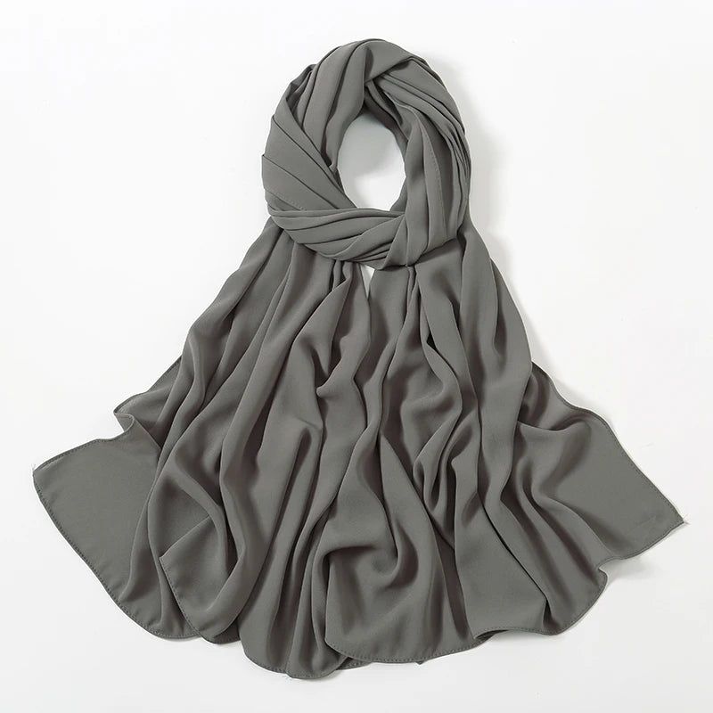 Drapierter, fester grauer Chiffon-Hijab-Schal, gefaltet und auf weißem Hintergrund präsentiert.