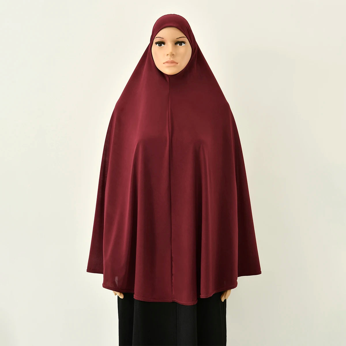 Modelin trägt eine maroonfarbene, flächendeckende Abaya mit innerer Hijab.