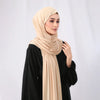Eine Frau trägt ein beige elegantes Modal-Jersey-Hijab mit Magnetverschluss und einem schwarzen Oberteil.