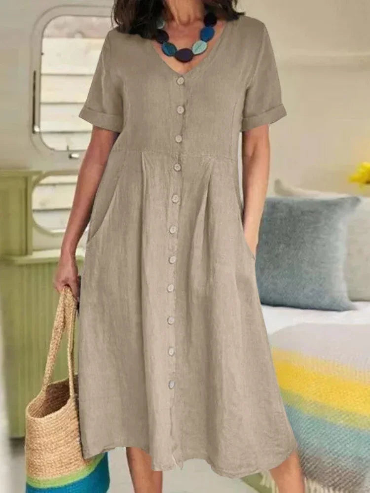 Eine Frau modelliert ein elegantes, lockeres, naturfarbenes Baumwoll- und Hanf-V-Ausschnittkleid.