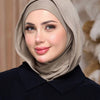 Eine Frau trägt einen beige Instant ready-to-wear Jersey-Hijab und ein schwarzes Oberteil.