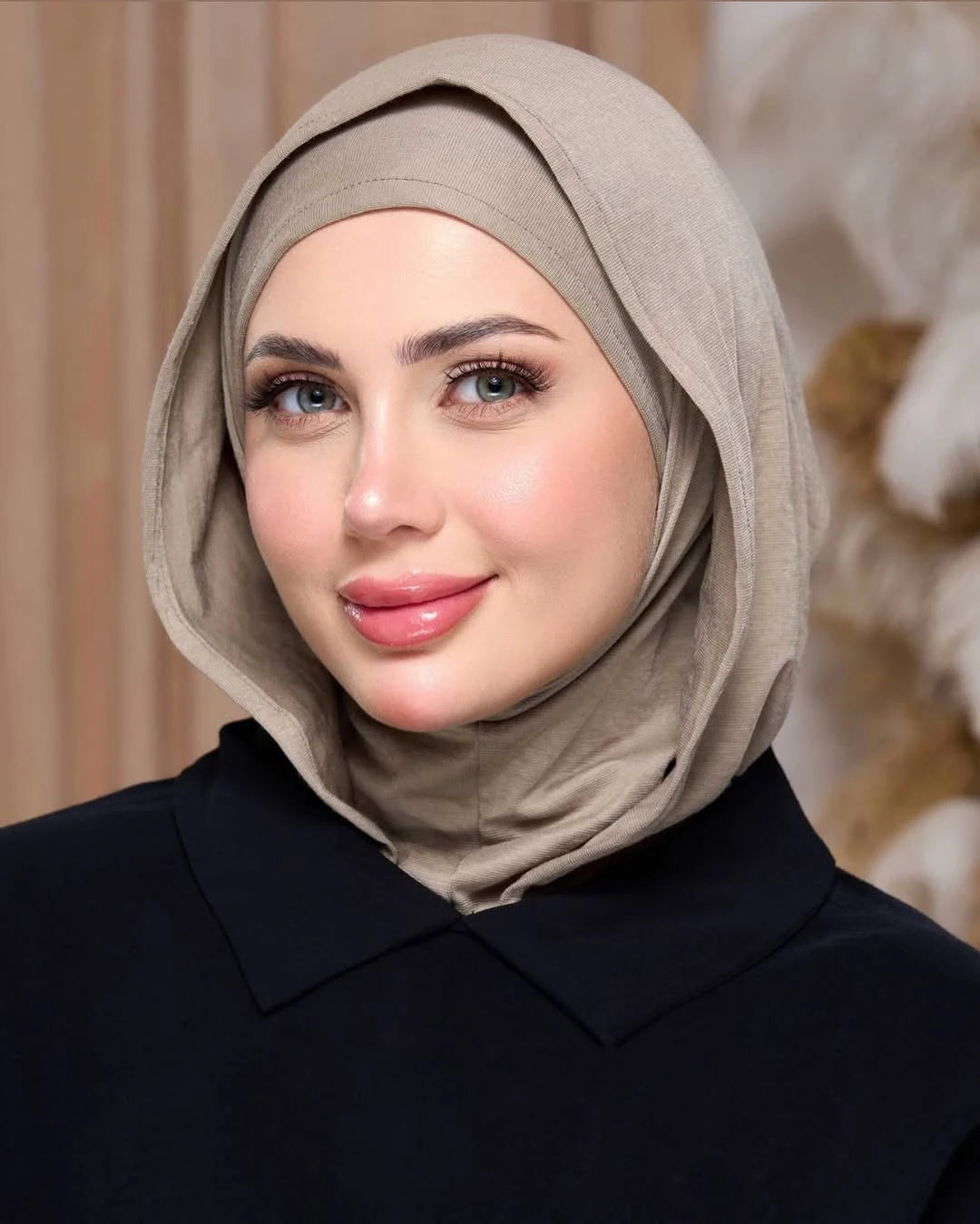 Eine Frau trägt einen beige Instant ready-to-wear Jersey-Hijab und ein schwarzes Oberteil.