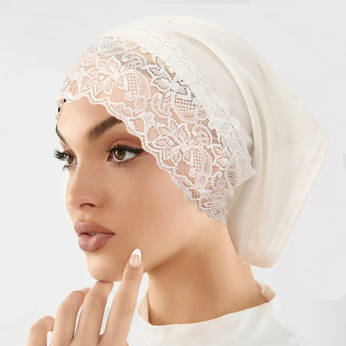 Nahaufnahme einer Frau mit cremefarbener Spitzen-Strumpfhose als Unterhijab-Turbanbonnet.