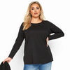 Une femme modélise un élégant t-shirt en coton noir à manches longues.
