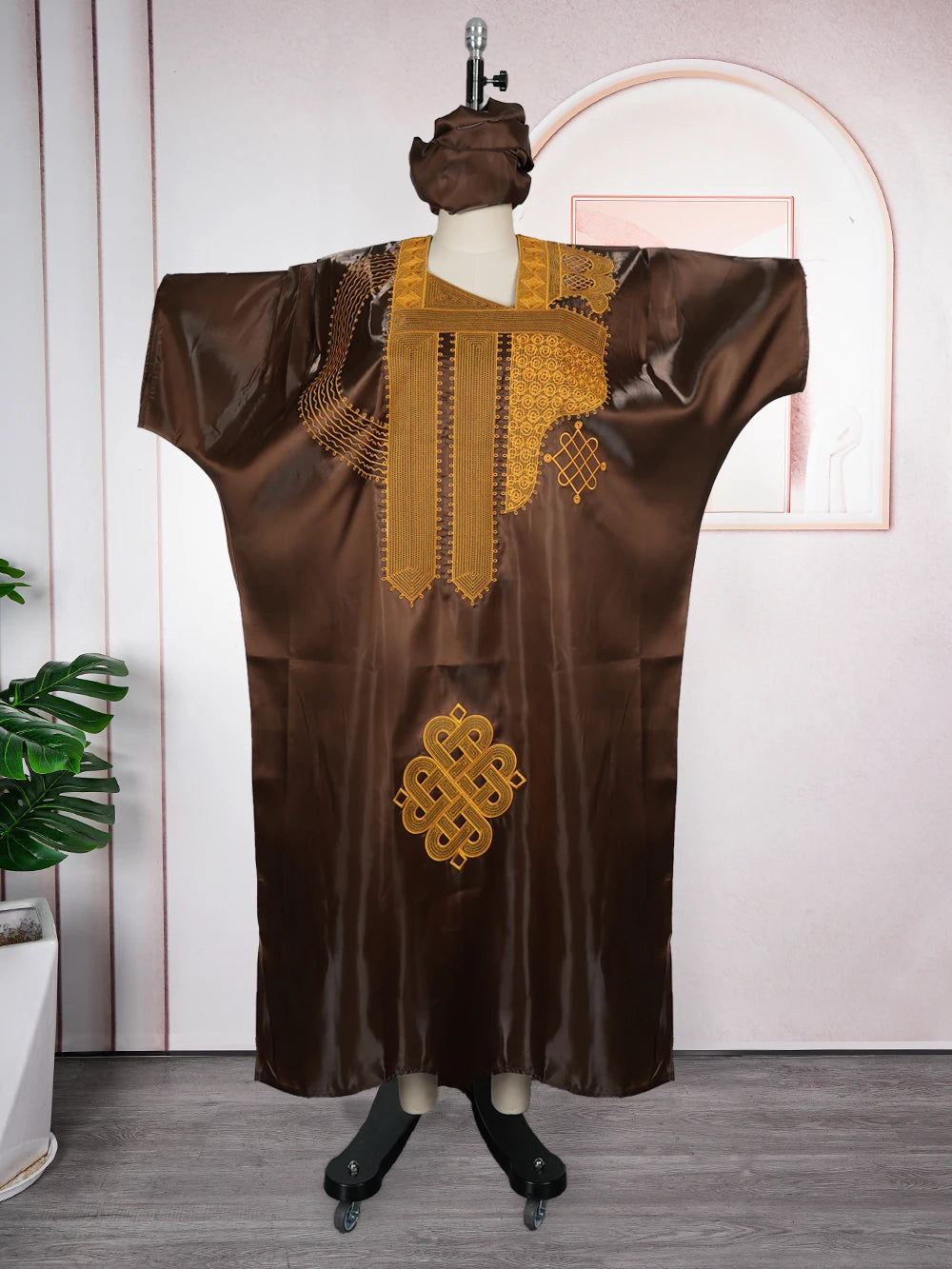 Dunkelbraunes traditionelles Ankara Dashiki-Kleid mit Goldstickerei auf einem Mannequin.