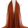 Ein drapierter, fester, verbrannter orangefarbener Chiffon-Hijab-Schal auf einem Mannequin-Hals.