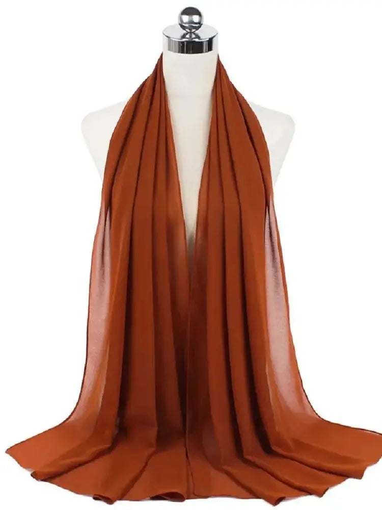 Ein drapierter, fester, verbrannter orangefarbener Chiffon-Hijab-Schal auf einem Mannequin-Hals.