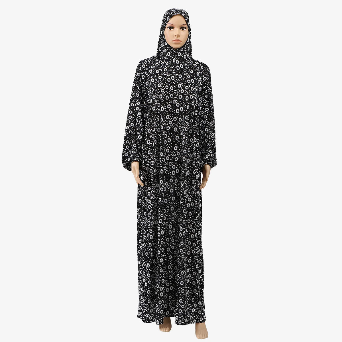 Una mujer vistiendo una abaya de lino floral negra con capucha y turbante.
