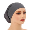 Ein Model trägt einen grauen weichen Modal-Baumwoll-Inner-Hijab als Turban auf dem Kopf.