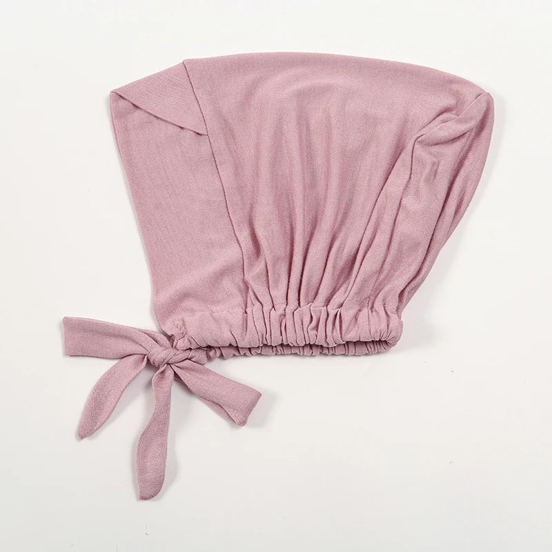 A soft dusty rose adjustable cotton jersey inner hijab cap tied at the bottom.