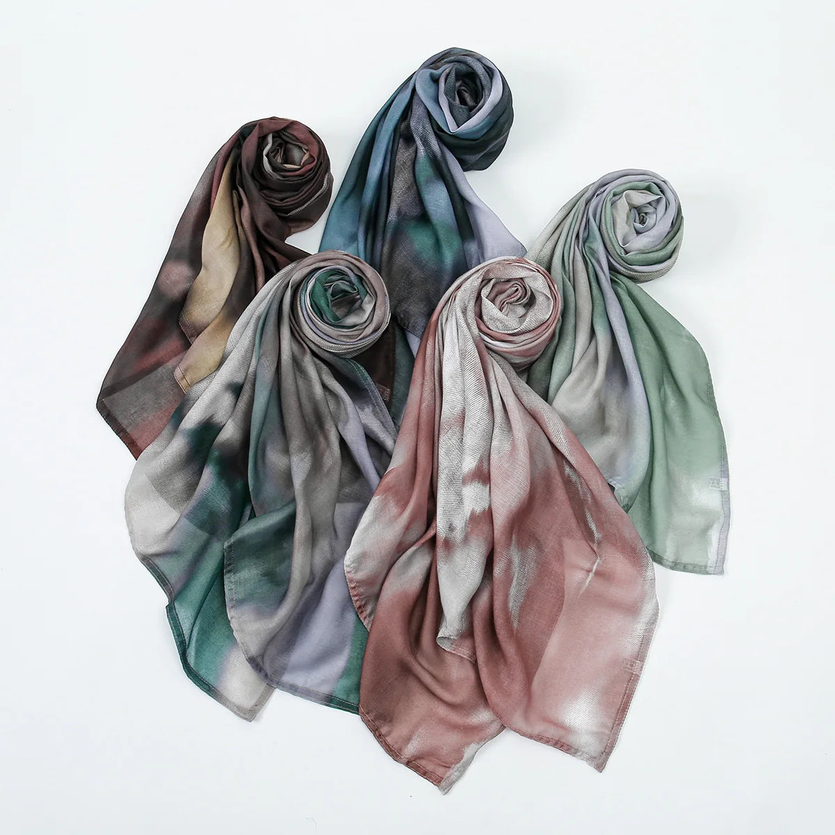 Eine Kollektion von sechs Aquarelldrucken in Baumwolle und Leinen-Hijab-Schals in gedämpften Erdtönen und Grüntönen.