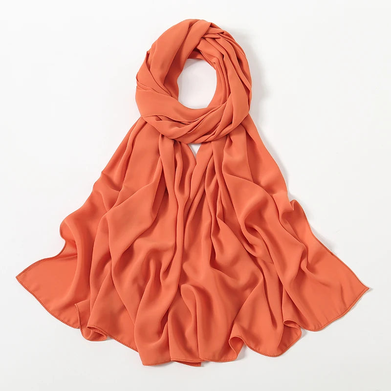 Fließender, verbrannter orangefarbener Chiffon-Schal um den Hals und die Schultern drapiert.