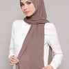 A woman wearing a mauve chiffon matching inner scarf set with a white top.