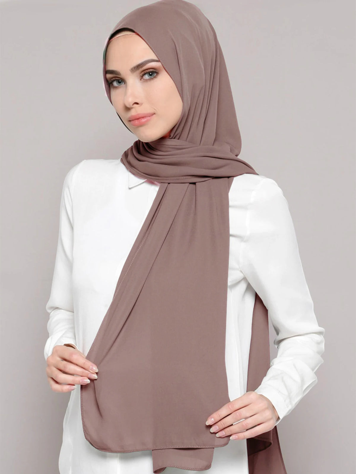 A woman wearing a mauve chiffon matching inner scarf set with a white top.