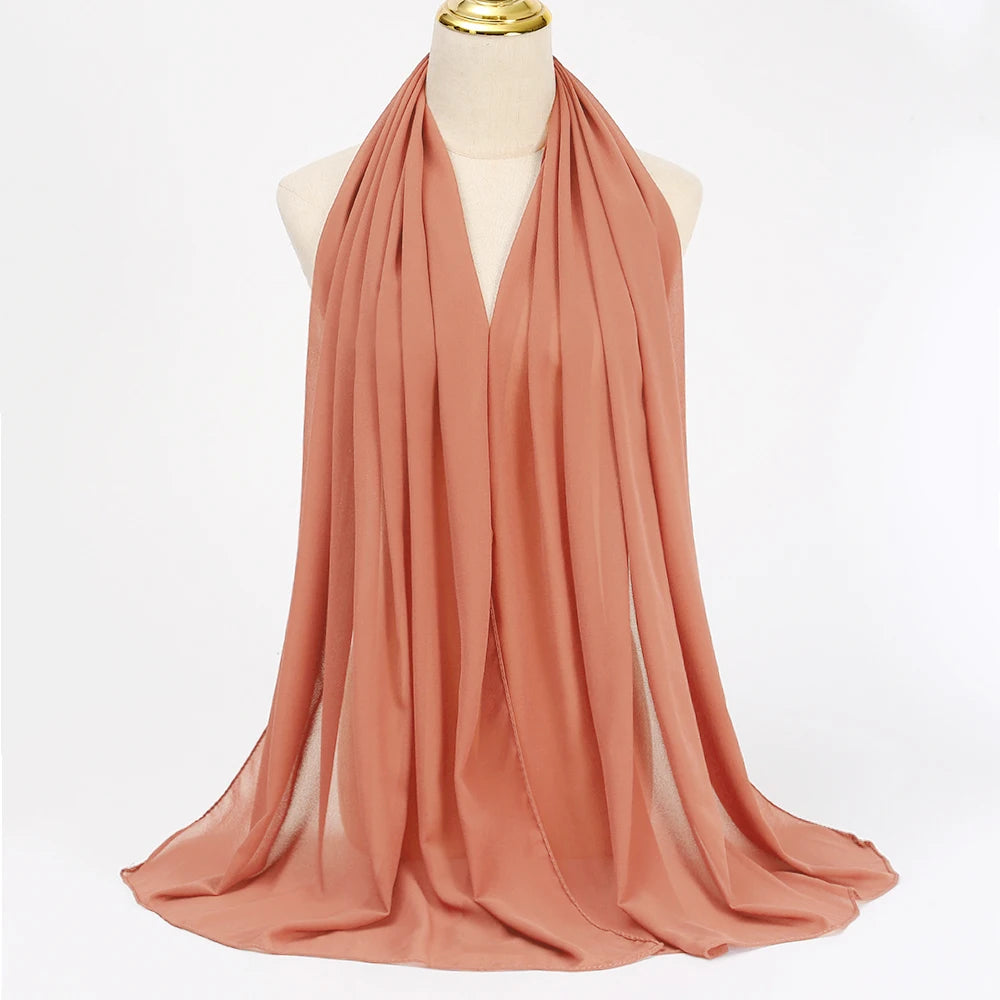 Fließender, fester Terrakotta-Chiffon-Hijab-Schal über dem Hals eines Mannequins drapiert.