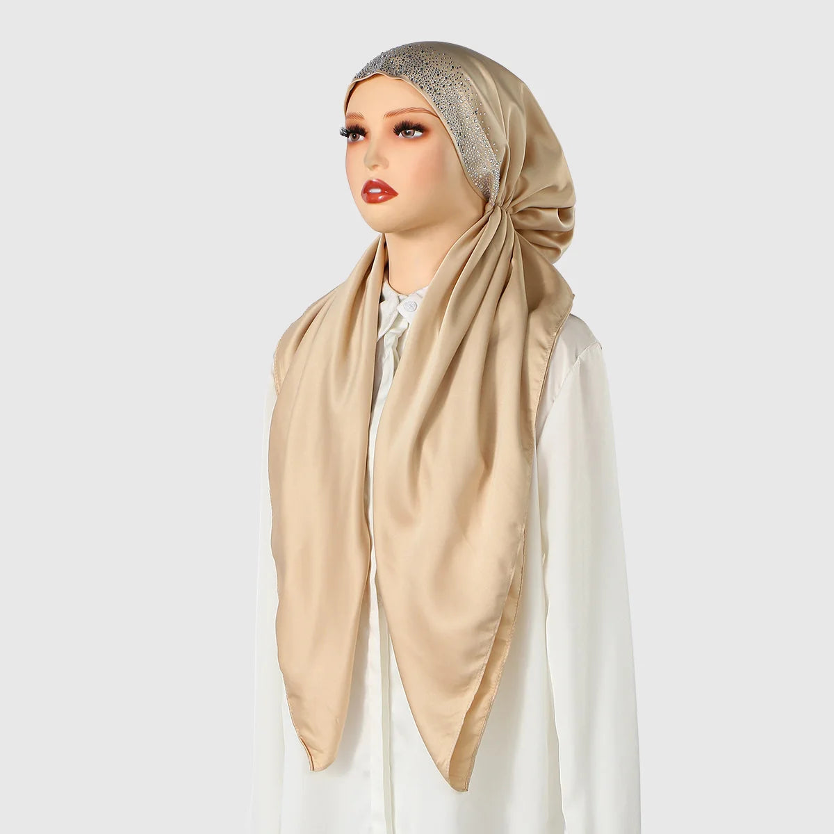 A model wears an elegant satin silk instant hijab scarf in beige with a silver sequin trim.