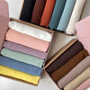 Sechs Chiffon-Hijabstoffrollen in gedämpften und pastelligen Farben in einer Holzbox.