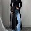 Eine Frau trägt einen schwarzen, gerippten Strick-Maxi-Cardigan über blauen Jeans.