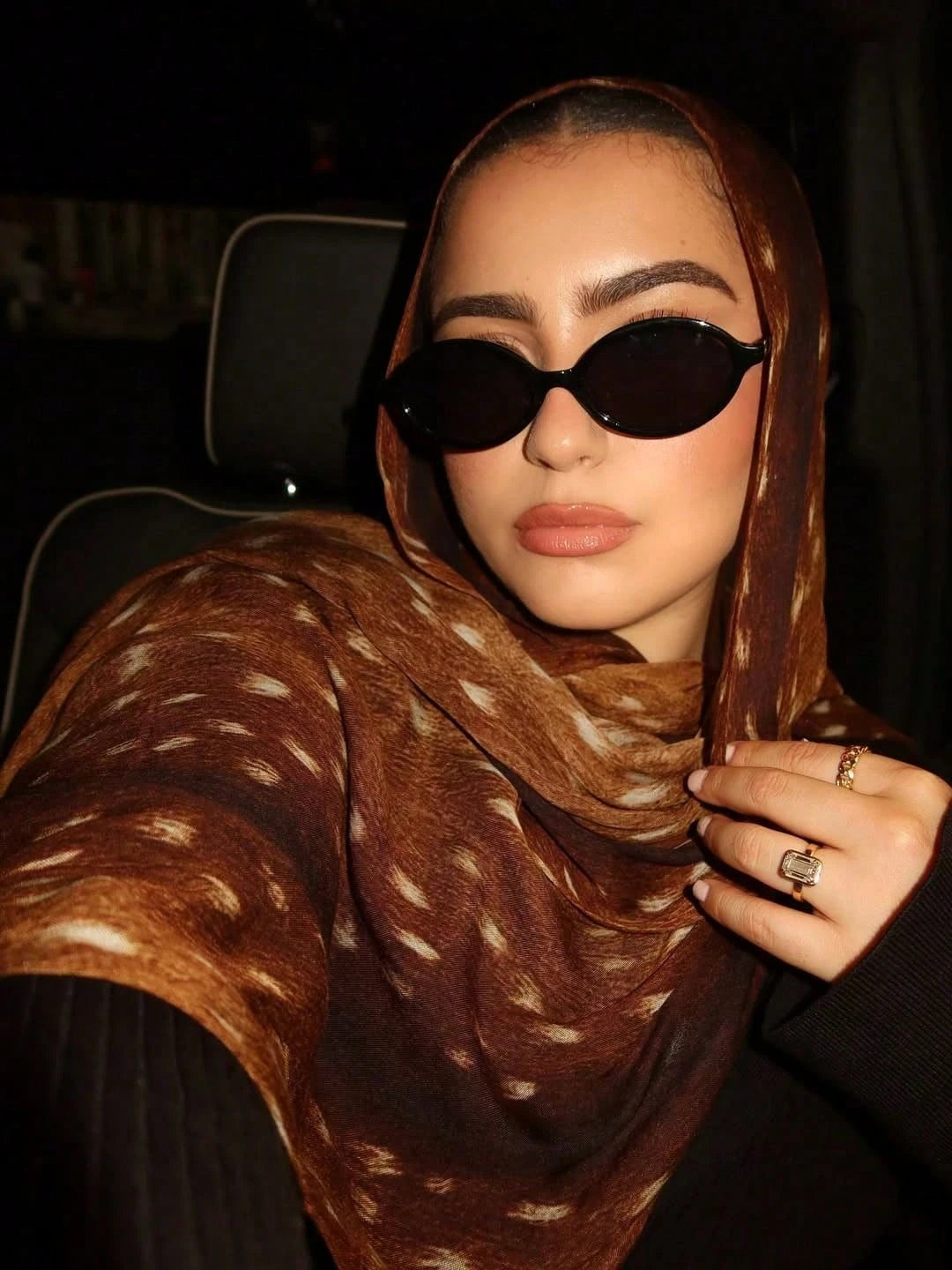 Eine Frau trägt einen braunen Aquarell-Hirschmuster-Hijab und Sonnenbrille.