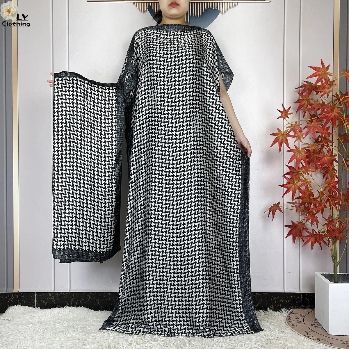 Eine Frau modelliert ein schwarz-weiß gemustertes Sommerseidenabaya-Kaftankleid.
