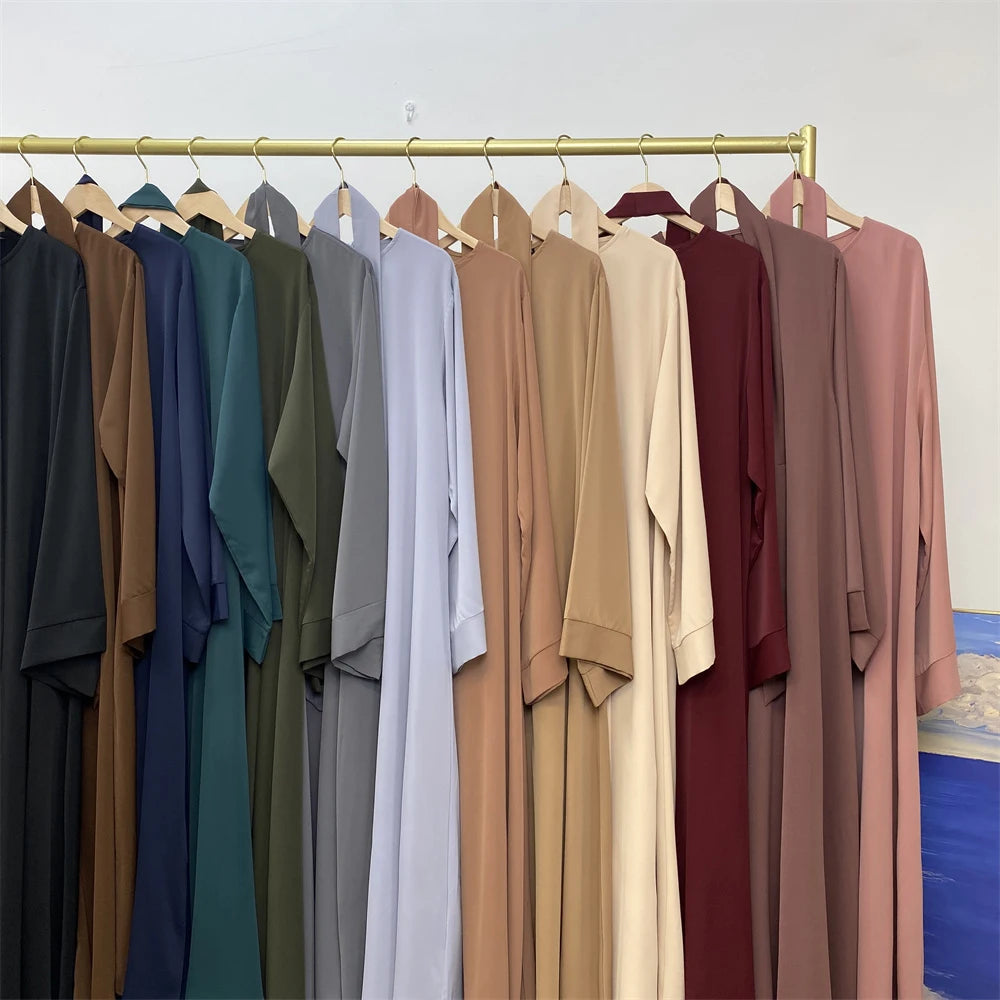 Exhibición de abayas de encaje elegantes para mujeres en varios tonos de verde oliva, azul, gris y beige.