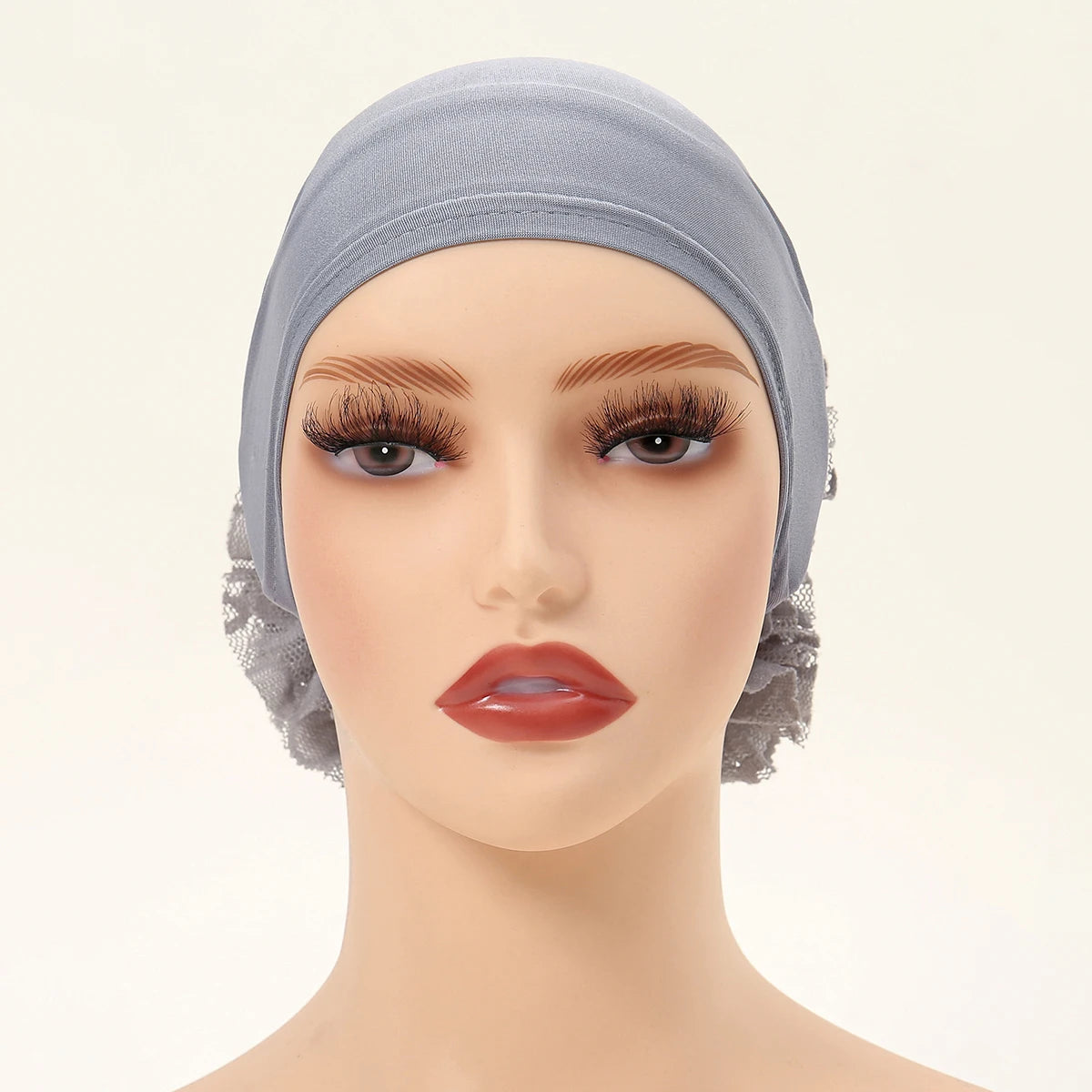 Ein Modell trägt eine hellblaue Spitzenblumen-Volumizer-Hijab-Kappe mit natürlichem Make-up.