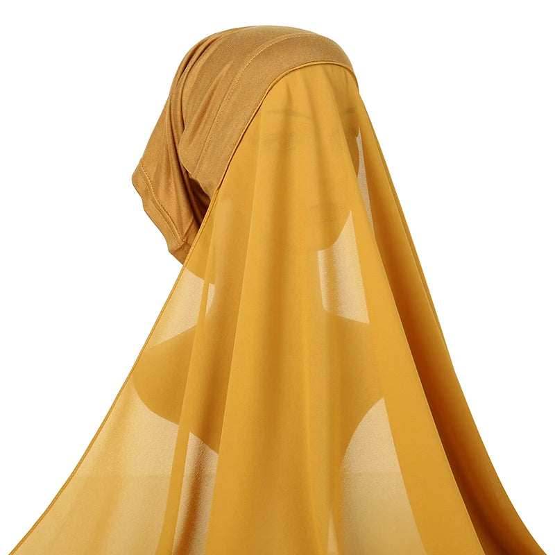 A close-up of a flowing mustard yellow chiffon instant hijab with a matching modal cotton cap.