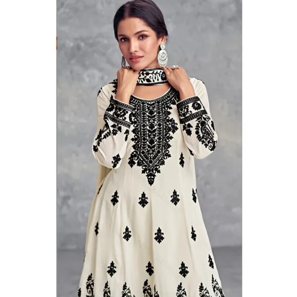 A woman models a cream and black Muslim ethnic two-piece set featuring intricate embroidery.