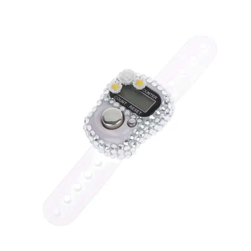 A white finger counter with a clear display and a crystal-like decorative element.