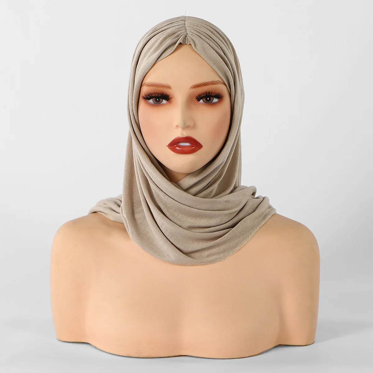 Une mannequin portant un foulard hijab triangle beige, vue de la poitrine.